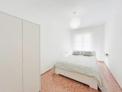 a white bedroom with a bed and a mirror at Global Vacacional, Apartamento de 3 dormitorios en Sagunto in Sagunto