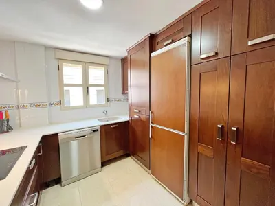 a kitchen with wooden cabinets and a refrigerator at Global Vacacional, Apartamento de 3 dormitorios en Sagunto in Sagunto