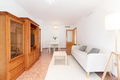 a living room with a white couch and a table at Global Vacacional, Apartamento de 3 dormitorios en Sagunto in Sagunto