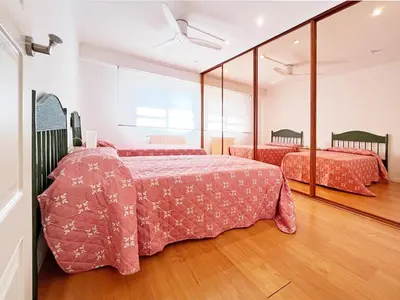 a bedroom with two beds and a mirror at Global Vacacional, Apartamento céntrico de 4 dormitorios in Puerto de Sagunto
