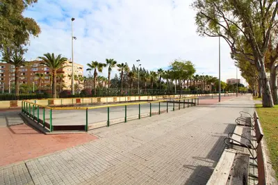 a park with benches and trees and palm trees at Global Vacacional, Apartamento céntrico de 4 dormitorios in Puerto de Sagunto