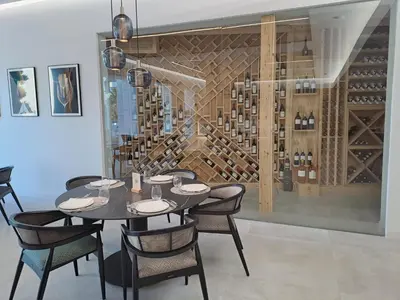 a dining room with a table and chairs and a wine cellar at DON LEONE Hotel in Alginet