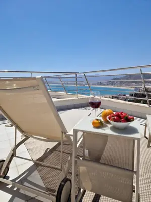 a table with a bowl of fruit and a glass of wine at Casa Buena Vista con piscina y ascensor in Cullera
