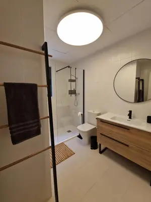 a bathroom with a sink and a toilet and a mirror at Casa Buena Vista con piscina y ascensor in Cullera
