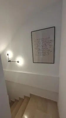 a stairway with a picture on the wall and a light at Casa Buena Vista con piscina y ascensor in Cullera