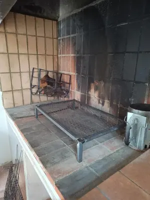 a fireplace with a metal rack in a room at Chalet El Tochar in Valencia
