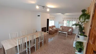 a living room with a dining table and chairs at Chalet El Tochar in Valencia