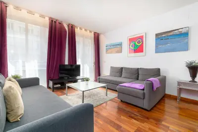 a living room with two couches and a tv at Baron Suites in Valencia