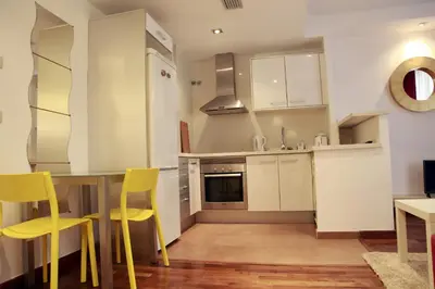 a kitchen with yellow chairs and a table in a room at Baron Suites in Valencia