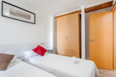 a bedroom with two white beds and a red pillow at apartamento con terraza in Valencia