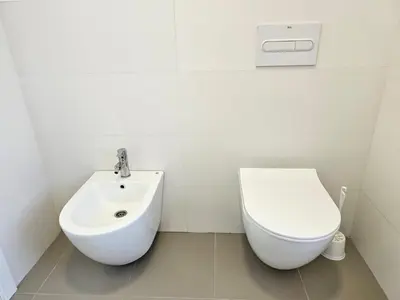 a white bathroom with a toilet and a sink at Apartamento a pie de playa I in Faro de Cullera