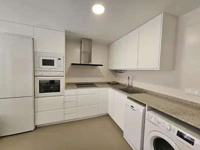 a white kitchen with white cabinets and a dishwasher at Apartamento a pie de playa I in Faro de Cullera