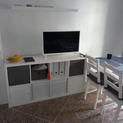 a white entertainment center with a flat screen tv on it at Mar y castillo in Cullera