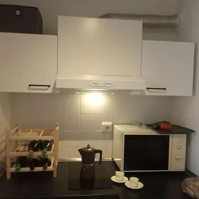 a kitchen with white cabinets and a black counter top at Mar y castillo in Cullera