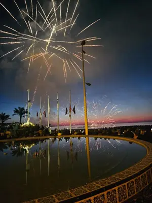 a firework display over a pool of water at night at Mar y castillo in Cullera