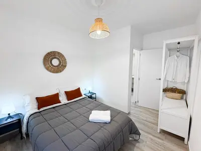 a white bedroom with a large bed with orange pillows at NUEVO, a 60 metros de la playa y con vistas laterales al mar in Cullera
