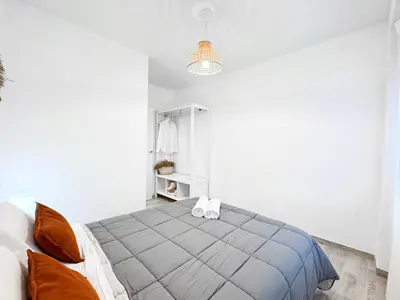 a bedroom with a large bed in a white room at NUEVO, a 60 metros de la playa y con vistas laterales al mar in Cullera