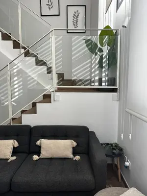 a living room with a couch and a staircase at Dúplex piscina, parking -Roig Arena -Las Ciencias in Valencia