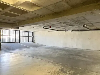 an empty room with a concrete floor in a building at Dúplex piscina, parking -Roig Arena -Las Ciencias in Valencia