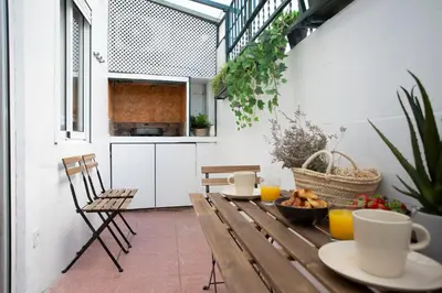 a patio with a wooden table with a bowl of food at SingularStays San Valero in Valencia