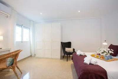 a bedroom with a bed and a chair and a table at SingularStays Gran Via in Valencia