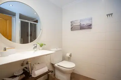 a white bathroom with a toilet and a mirror at SingularStays Gran Via in Valencia