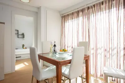a dining room with a table and white chairs at SingularStays Benimaclet in Valencia