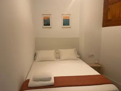 a bed in a bedroom with two pictures on the wall at Estudio Pino en casco antiguo VALENCIAYOLE in Valencia
