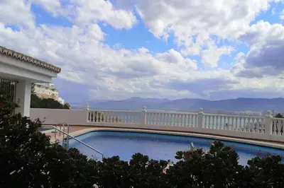 a balcony with a swimming pool and a white fence at Apartamentos Bon Amb in Faro de Cullera