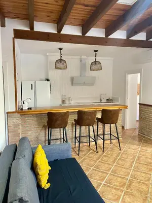 a living room with a blue couch and a kitchen at UIM Planta baja Canovas del Castillo, PLAYA WIFI in Puerto de Sagunto
