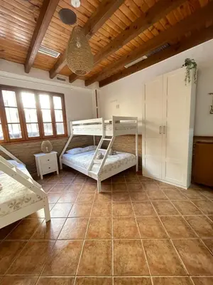 a bedroom with two bunk beds and a wooden ceiling at UIM Planta baja Canovas del Castillo, PLAYA WIFI in Puerto de Sagunto