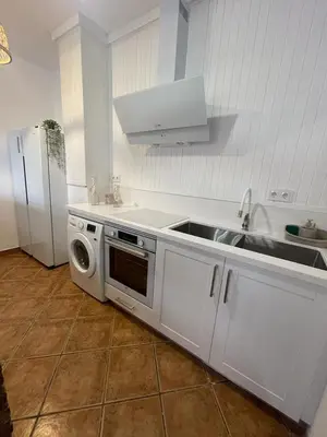 a kitchen with a sink and a stove and a microwave at UIM Planta baja Canovas del Castillo, PLAYA WIFI in Puerto de Sagunto