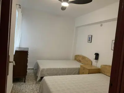 a bedroom with two beds and a ceiling fan at RIU MAR Apartment Cullera in Cullera