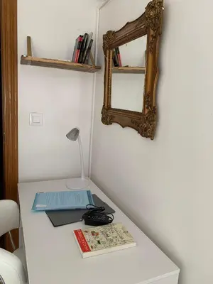 a table with a mirror and a lamp and books at Sagunto in Sagunto