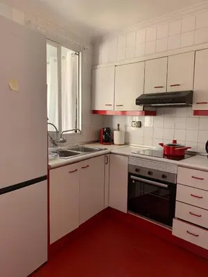 a kitchen with white cabinets and a sink and a stove at Sagunto in Sagunto
