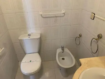 a white bathroom with a toilet and a sink at Apartamento Castillo - Alquiler de temporada in Puerto de Sagunto