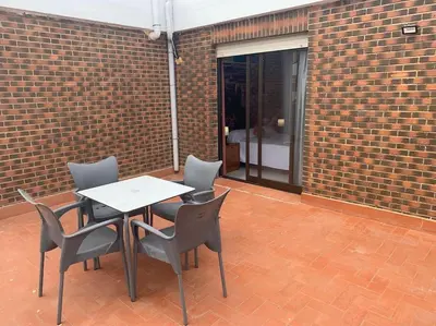a table and chairs in front of a brick wall at Apartamento Castillo - Alquiler de temporada in Puerto de Sagunto