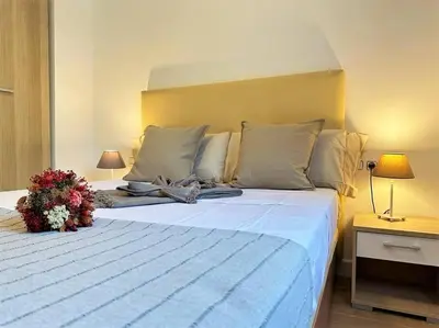 a bedroom with a large white bed with flowers on it at Your Poolside Paradise by the Sea in Port Saplaya