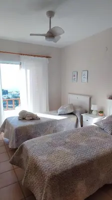 a bedroom with two beds and a ceiling fan at Una casa con vistas in Faro de Cullera