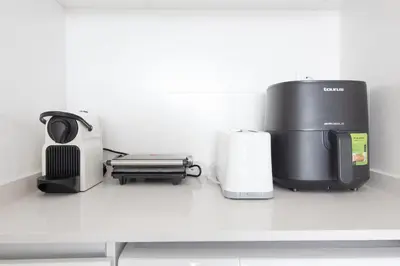 a coffee maker and a toaster on a counter at Global Vacacional, Apartamento con terraza, vistas al mar y a la piscina in Canet de Berenguer