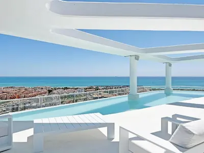 a swimming pool on top of a building with the ocean at Global Vacacional, Apartamento con terraza, vistas al mar y a la piscina in Canet de Berenguer