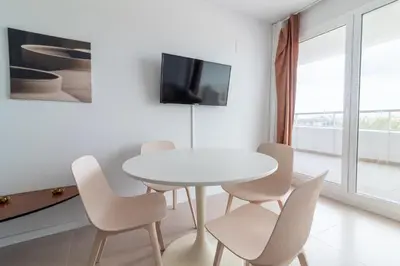 a white dining room with a white table and chairs at Global Vacacional, Moderno apartamento con terraza en Gran Canet in Canet de Berenguer