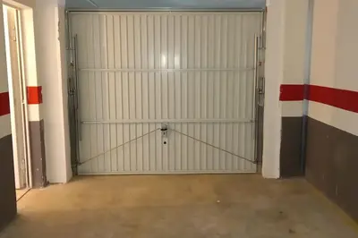 a garage with white garage doors in a room at Terraced house in natural essence in Favareta
