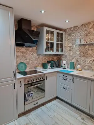 a large kitchen with white cabinets and appliances at Cullera Confort Playa in Cullera