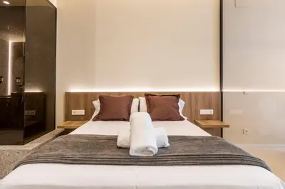 a bedroom with a large bed with towels on it at North Station PEN-SUITES in Valencia