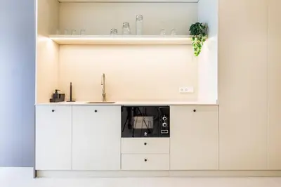 a kitchen with white cabinets and a sink at North Station PEN-SUITES in Valencia