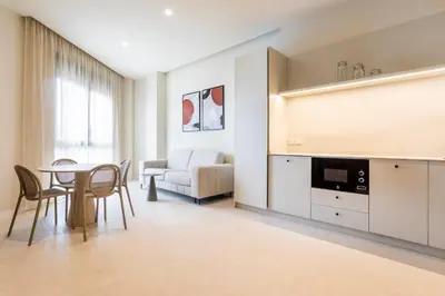 a living room with a dining table and a tv at North Station PEN-SUITES in Valencia