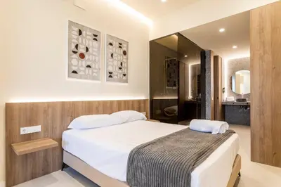 a bedroom with a large bed and a bathroom at North Station PEN-SUITES in Valencia