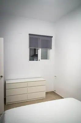 a white bedroom with a window and a white dresser at Casa vacacional El Sol in Turís