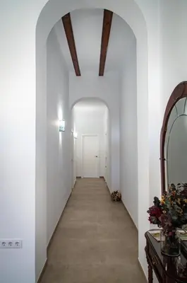a hallway with white walls and a ceiling with wooden beams at Casa vacacional El Sol in Turís